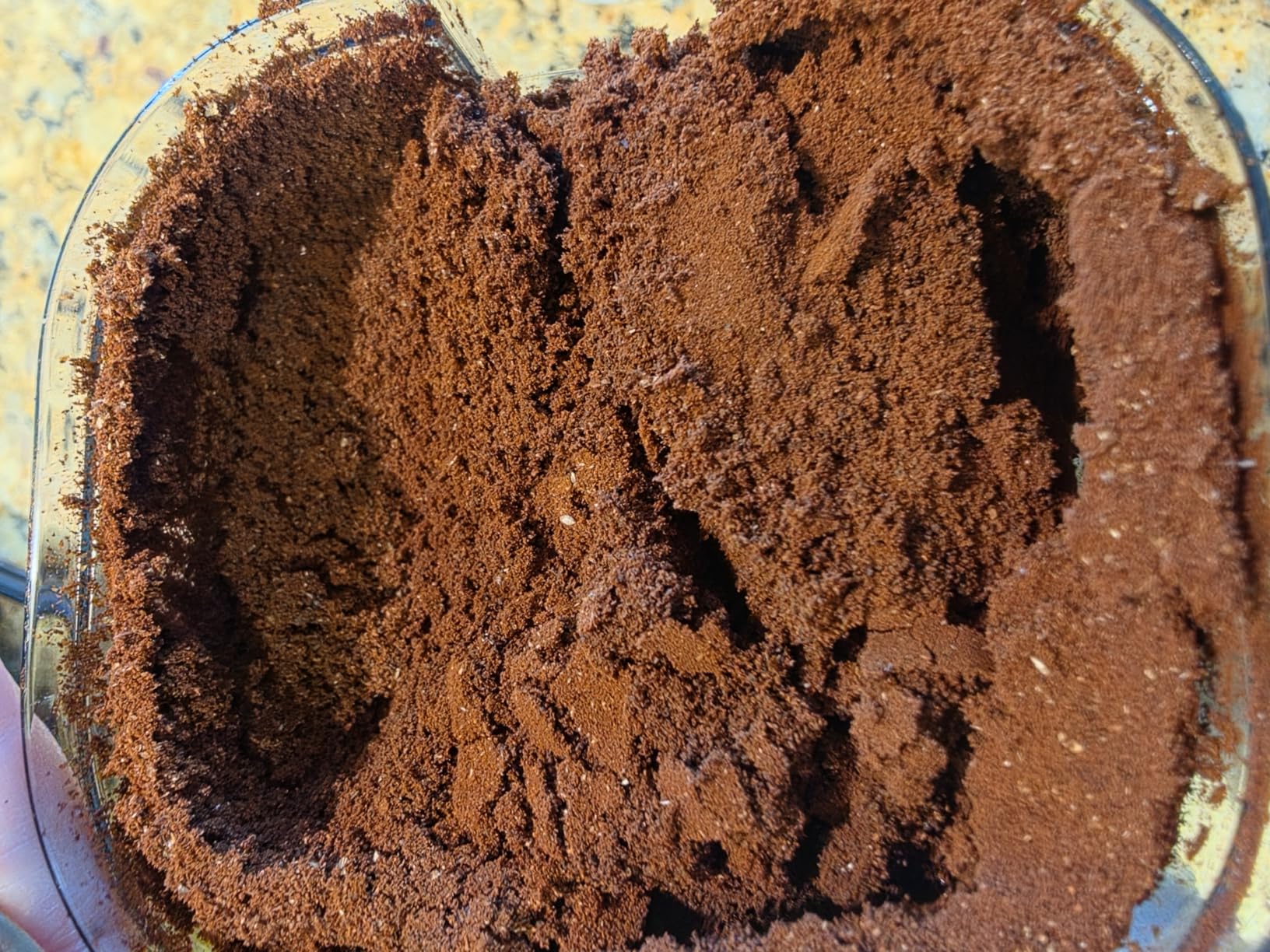 Close-up of fine, even coffee grounds in an Ollygrin grounds container